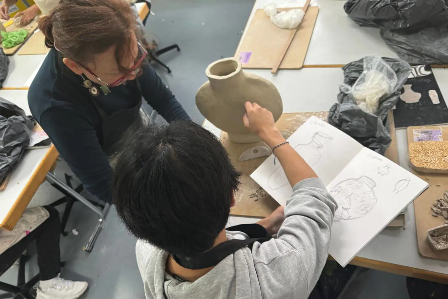 ISD Senior School pupil sculpting a vase in a visual arts lesson.