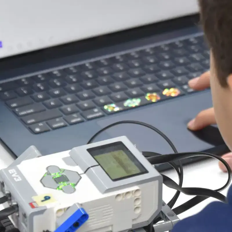 ISD pupil working on a robotics project with a laptop.