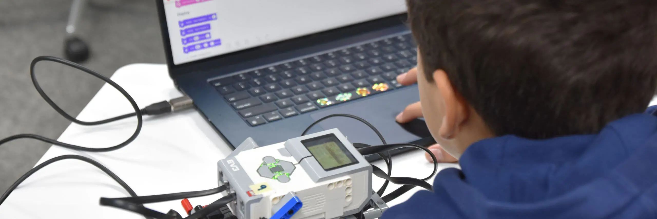 ISD pupil working on a robotics project with a laptop.